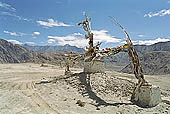 Ladakh - pile of stones on  mountain pass with the characteristc prayer flags 